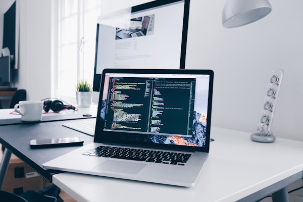 MacBook displaying code on a developer desk